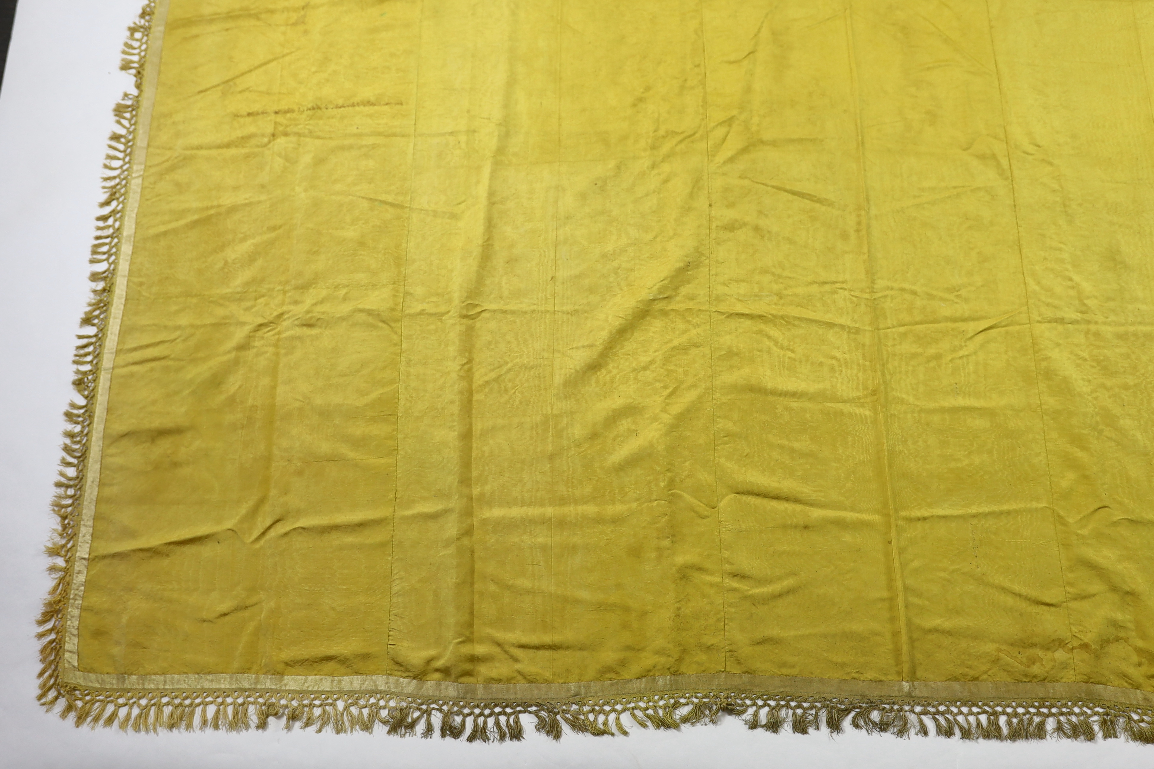 A large Regency yellow silk curtain, with fringed base, French short loom ribbed silk panels made into a wide curtain, with fringing on each side and at the bottom, 9ft wide x 8ft 6in. long